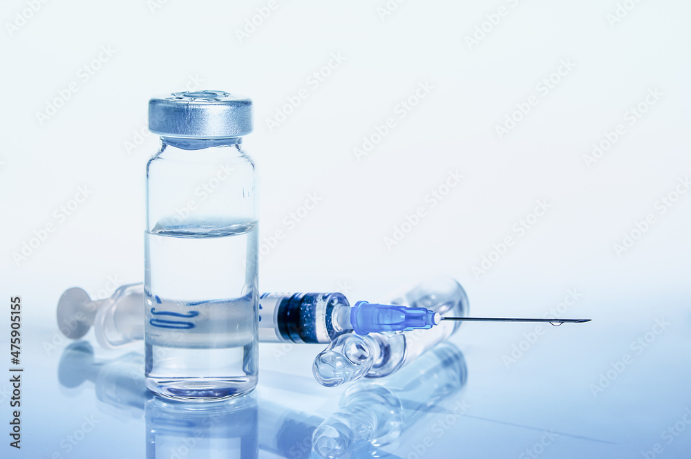 syringe and diferent kind of ampoules and vials close-up on white background with reflection syringe and diferent kind of ampoules and vials close-up on white background with reflection