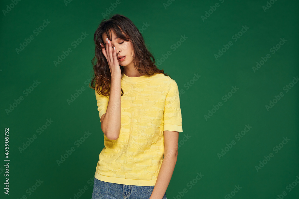 Facepalm gesture. Frustrated young girl covering face with hand, feeling shame, disappointment on green background Facepalm gesture. Frustrated young girl covering face with hand, feeling shame, disappointment on green background