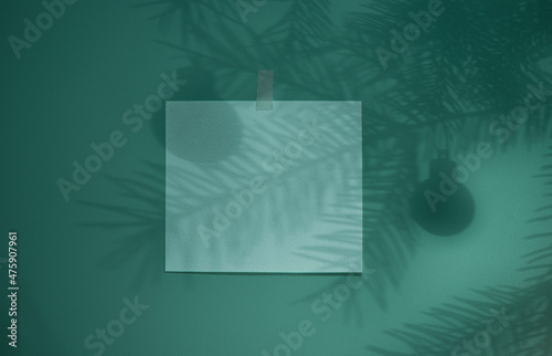 New Year or Christmas card, poster, advertising poster, announcement. The branches of the Christmas tree cast shadows on the blue wall. Copy space for text.
