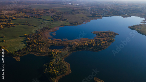 Top view of fall forest and lake. Autumn sunny evening over a forest lake.