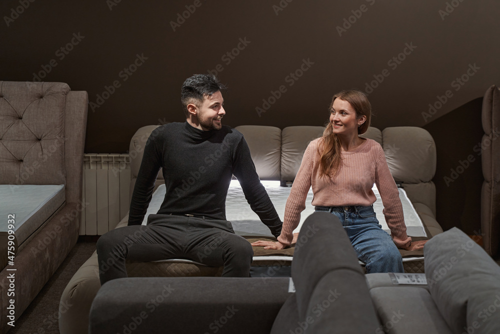 Young Caucasian couple shopping for new mattress Young Caucasian couple shopping for new mattress