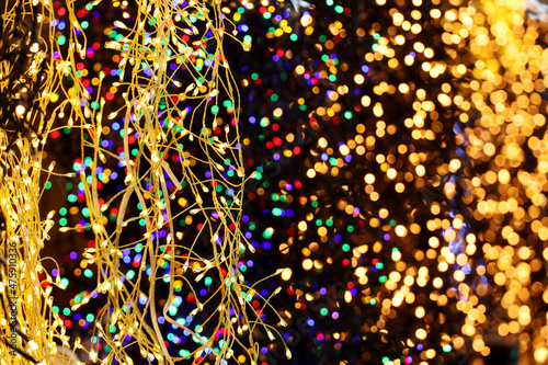 Festive lights on electric garlands. Colorful Christmas illumination, New Year decorations in a shop