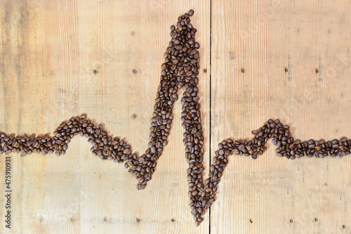 A QRS complex of the electrocardiogram was formed from roasted coffee beans on an old wooden board