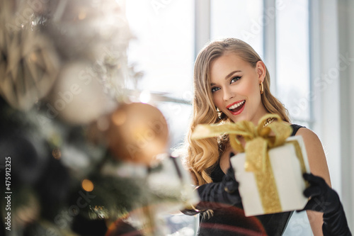 girl holds out a gift box to the camera