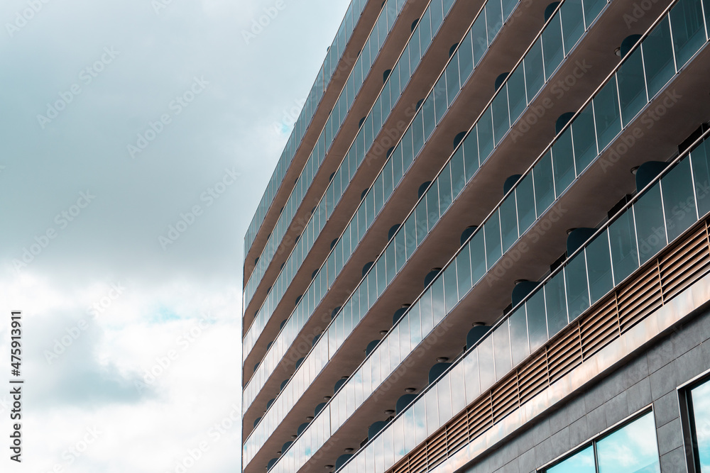 Glazed facade of a modern building, against the cloudy sky. Glazed facade of a modern building, against the cloudy sky.