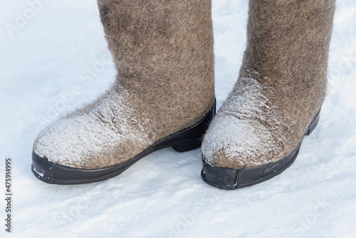 A man in felt boots in the snow.