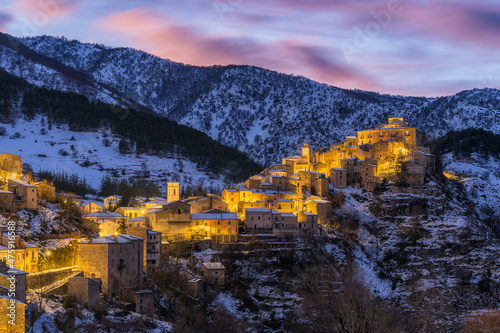 The beautiful village of Villalago, covered in snow at sunset during winter season. Province of L'Aquila, Abruzzo, Italy. photo