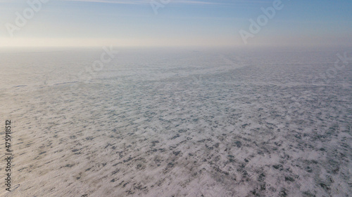 Lake Khanka in the Primorsky Territory in winter. View from above. Frozen coast of a large lake. Arctic landscape.