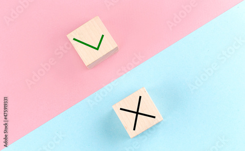 True and false symbols on wooden block on the pink and blue background photo