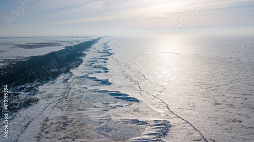 Lake Khanka in the Primorsky Territory in winter. View from above. Frozen coast of a large lake. Arctic landscape. Ice ridges on the coast of a large lake.