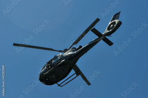 Fotografia Closeup shot of a Helicopter flying in the blue sky