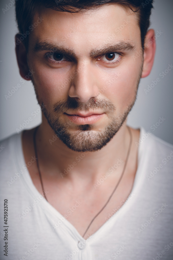 Obraz premium Fashionable male studio portrait. Caucasian white bug with bristles. A large portrait of a guy in a white T-shirt.