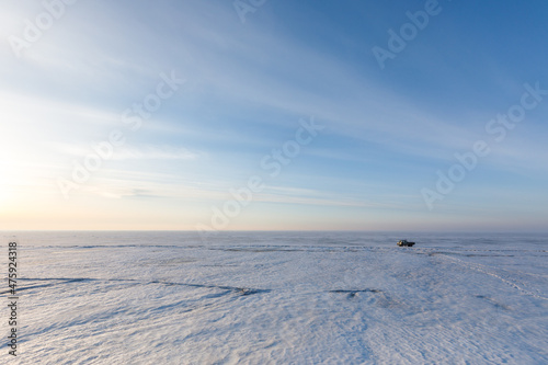 Lake Khanka in the Primorsky Territory in winter. View from above. Frozen coast of a large lake. Arctic landscape. Picturesque ice lake during sunset. © alexhitrov