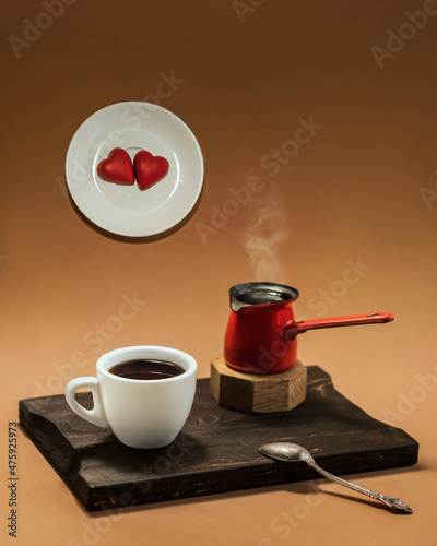 Tablou pe pânză Cup of coffee with steaming cezve on a wooden board