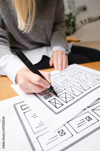 Woman designer create website design wireframe. Sketch, prototype, framework, layout future design project. UI and UX - user interface, user experience designer. Creative concept for web design studio