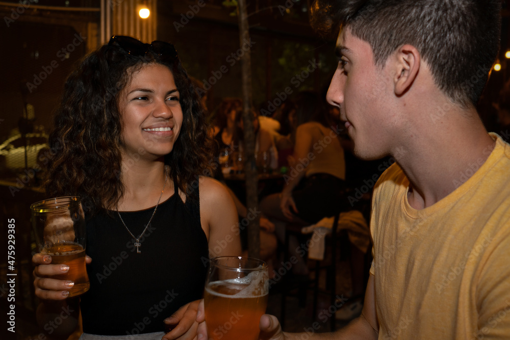 Young pretty latina flirts with young man in a bar. Young pretty latina flirts with young man in a bar.
