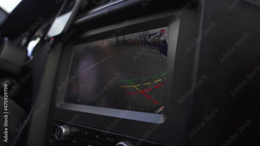 Man driving in innovative automated sport car using parking screen for parking on parking lot Man driving in innovative automated sport car using parking screen for parking on parking lot