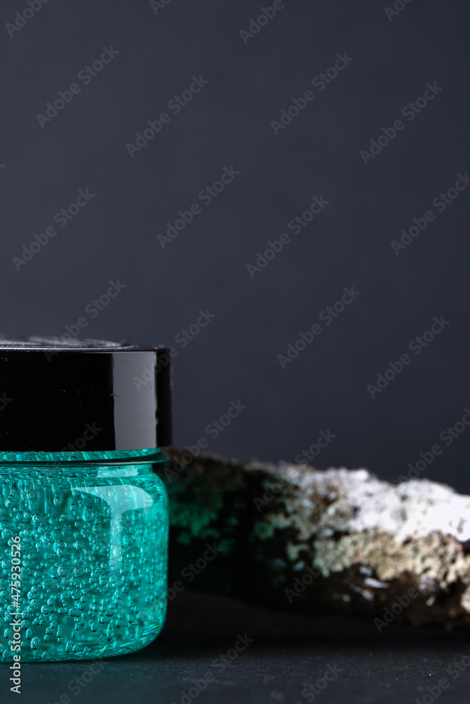 Close-up of a jar of cosmetics on an abstract dark background. Turquoise gel. Selective focus. copy space Close-up of a jar of cosmetics on an abstract dark background. Turquoise gel. Selective focus. copy space