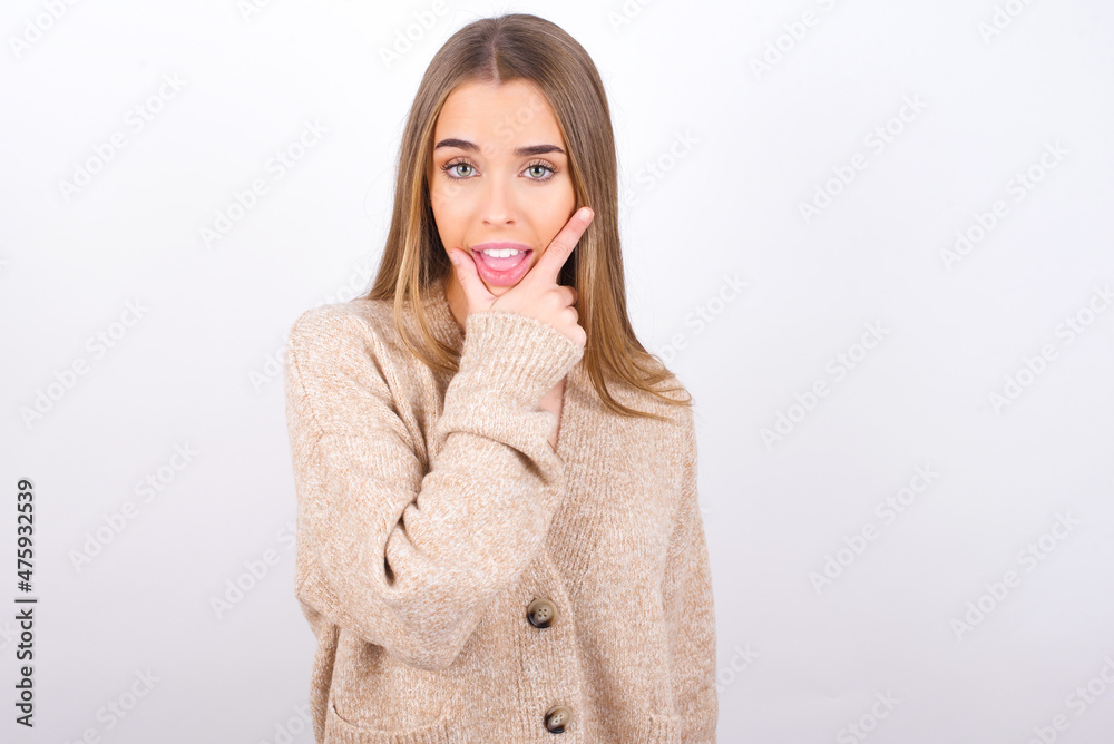 young caucasian girl wearing knitted sweater over white background looking confident at the camera smiling with crossed arms and hand raised on chin. Thinking positive. young caucasian girl wearing knitted sweater over white background looking confident at the camera smiling with crossed arms and hand raised on chin. Thinking positive.