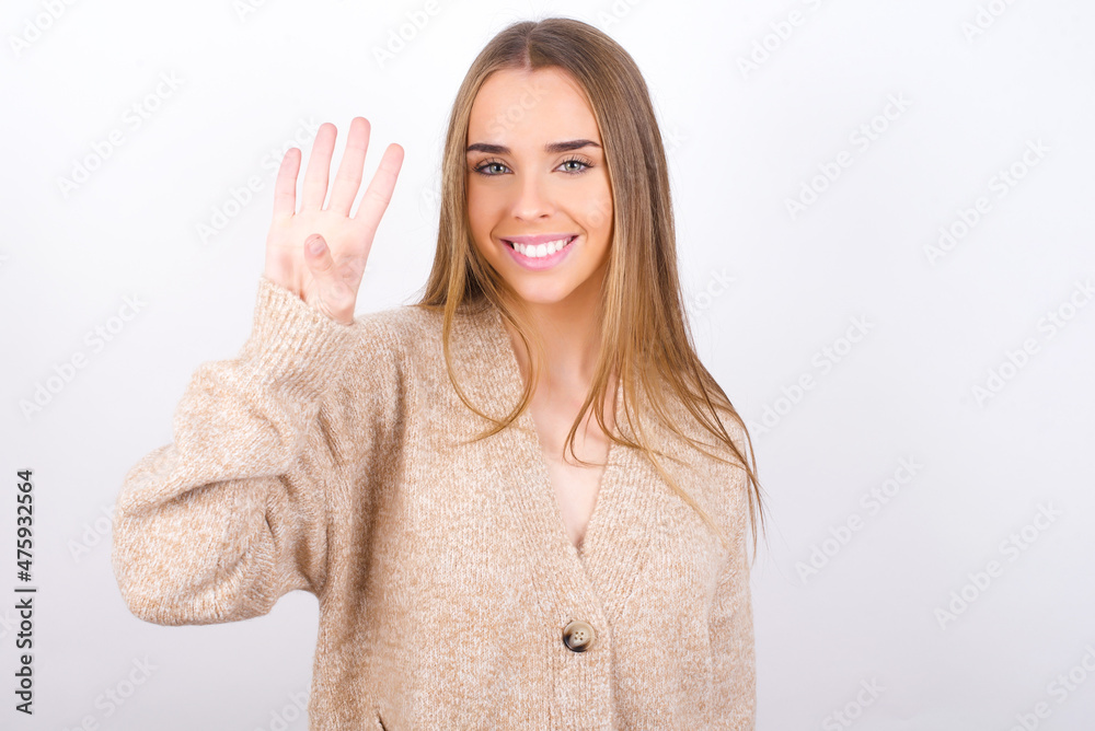 young caucasian girl wearing knitted sweater over white background showing and pointing up with fingers number four while smiling confident and happy. young caucasian girl wearing knitted sweater over white background showing and pointing up with fingers number four while smiling confident and happy.