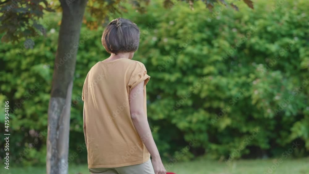 Woman plays frisbee on grass lawn. Summer vibes. Outdoor leisure activity. Family life. Sports game at backyard. Woman plays frisbee on grass lawn. Summer vibes. Outdoor leisure activity. Family life. Sports game at backyard.