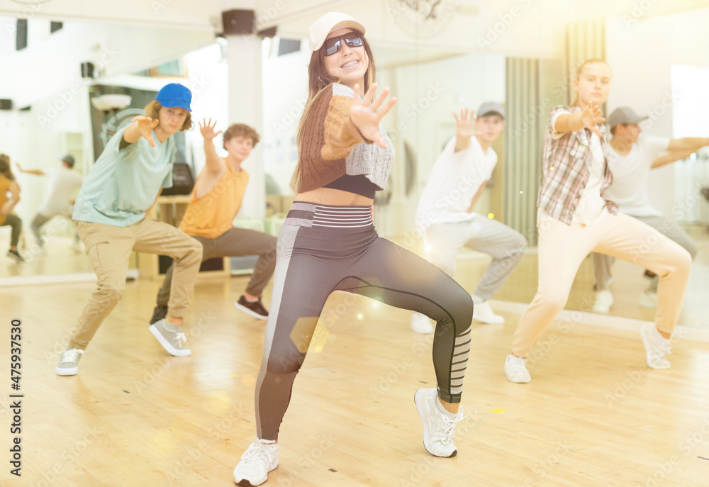 Obraz premium Teens training hip-hop dance moves during group rehearsal in studio.