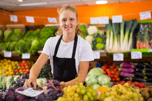 Fotografie Hardworking fifteen-year-old girl who works part-time in a store as a trainee sa