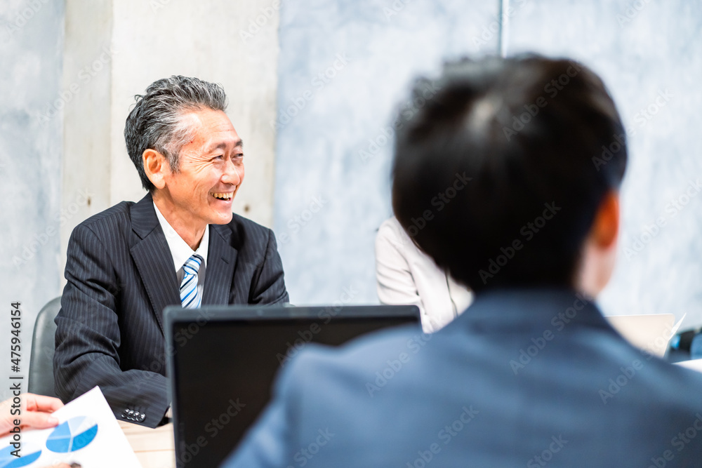 明るい雰囲気で会議をするビジネスパーソン 明るい雰囲気で会議をするビジネスパーソン