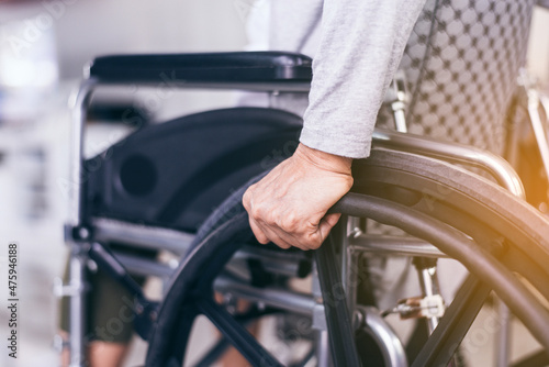 Cropped view of senior woman hands holding on wheelchair at home