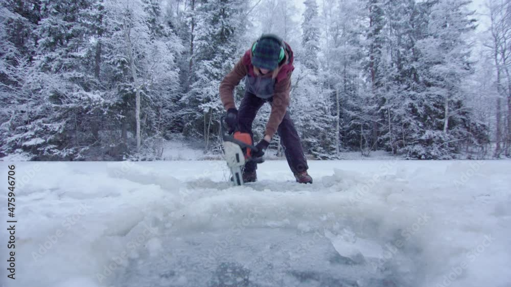 DRAMATIC CHAINSAW WOMAN ACTION - cutting ice bathing hole DRAMATIC CHAINSAW WOMAN ACTION - cutting ice bathing hole