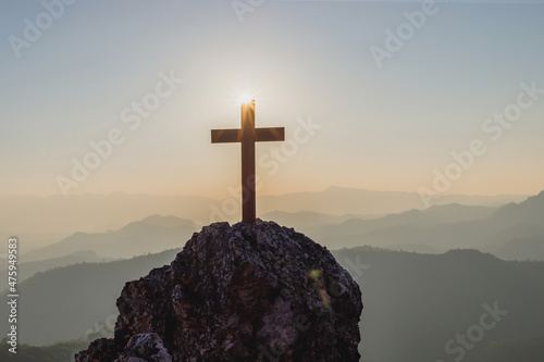 Fotografie, Obraz Silhouettes of crucifix symbol on top mountain with bright sunbeam on the colorf