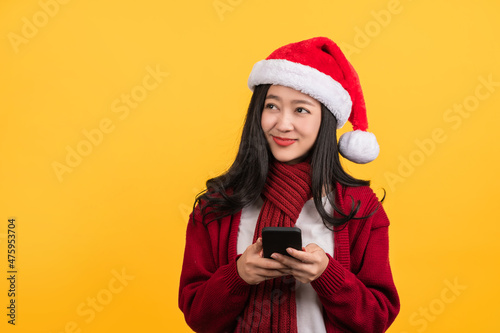 Happy santa girl with mobile in the red sweater isolated. Happy New Year 2022 celebration holiday party concept. Mock up copy space