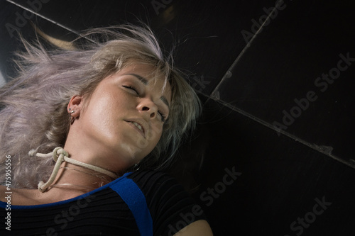 Schilderij op canvas Crime scene simulation: dead girl with hands tied lying on the floor