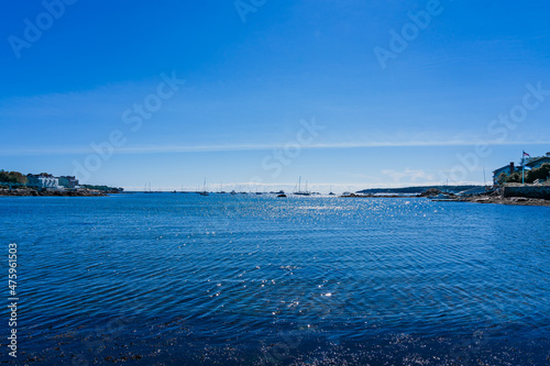 Bluewater with sun flares in the Atlantic gulf in the morning. Numerous yachts mooring in the distance