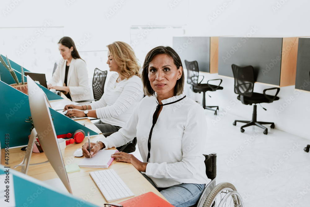 Latin transgender woman working with computer at the office in Mexico ...
