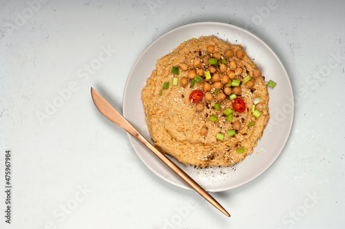 Chickpea hummus isolated on grey plate with bronze knife