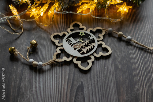 Christmas composition on a wooden background, Christmas cones and balls, green sprigs of needles, yellow lanterns in the form of stars and space for text, beautiful decoration for the home and design