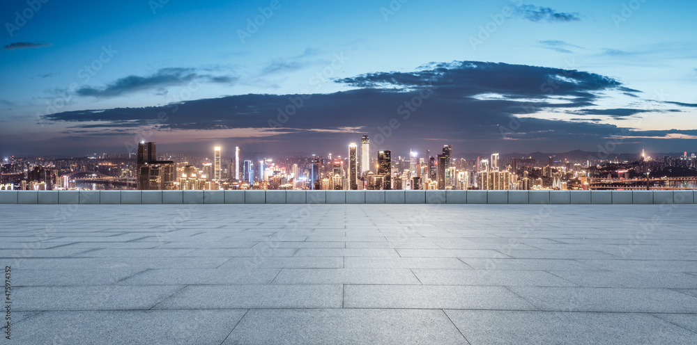 Panoramic skyline and modern commercial buildings with empty square at night