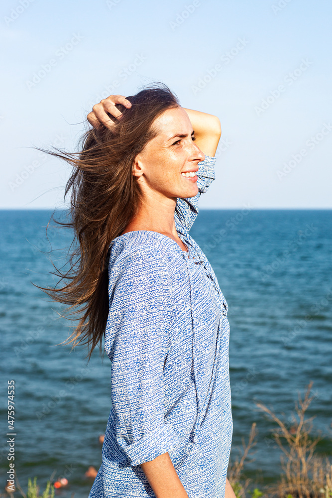Beautiful young woman in dress on the cliff against the background of the sea. Beautiful young woman in dress on the cliff against the background of the sea.