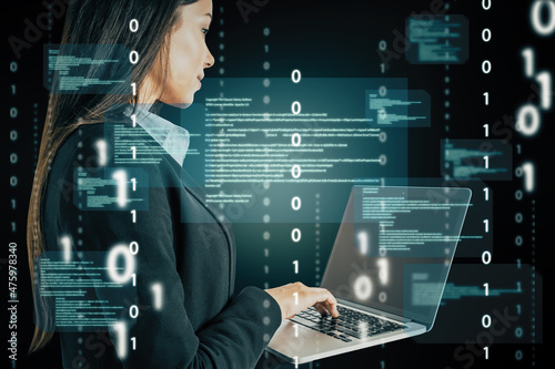 Attractive european businesswoman using laptop computer with abstract coding binary code hologram on blurry background. Artificial intelligence and development concept. Double exposure.
