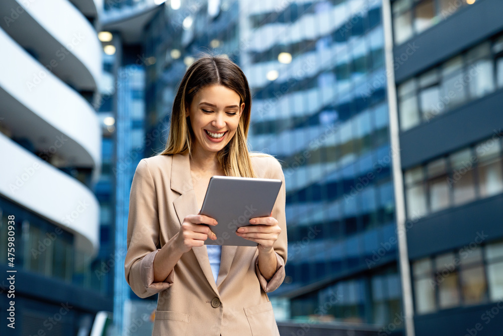 Fototapeta premium Successful businesswoman using a digital tablet while standing in front of business building.
