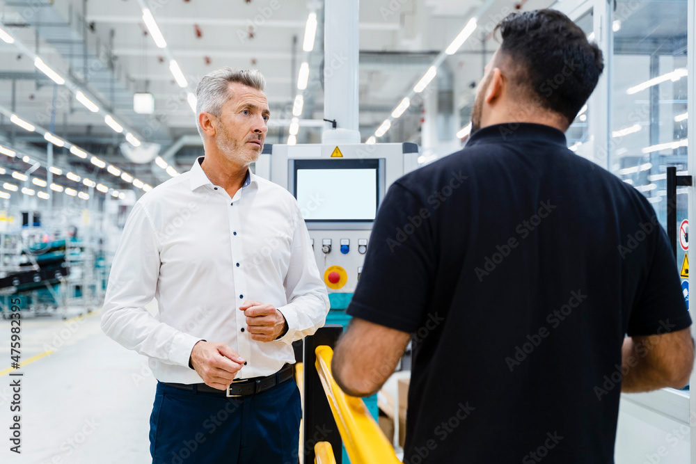Businessman discussing with maintenance engineer at electrical industry Businessman discussing with maintenance engineer at electrical industry