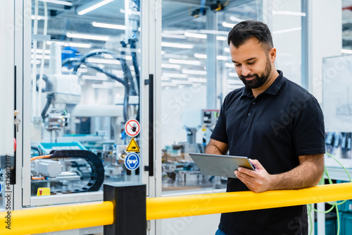 Maintenance engineer using tablet PC at electrical industry photo