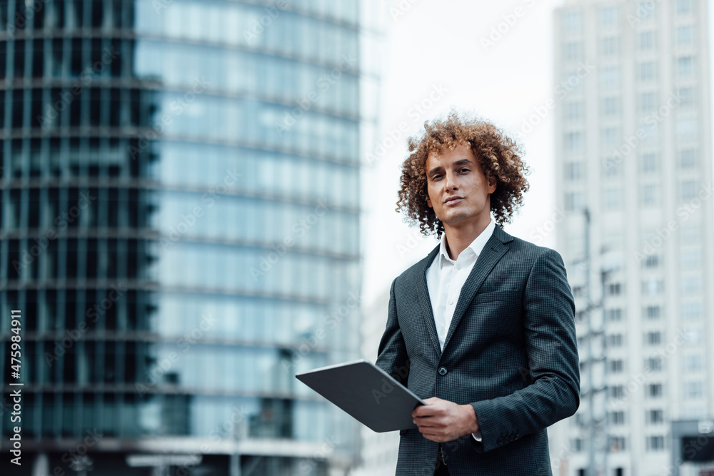 Confident businessman holding tablet PC in city Confident businessman holding tablet PC in city