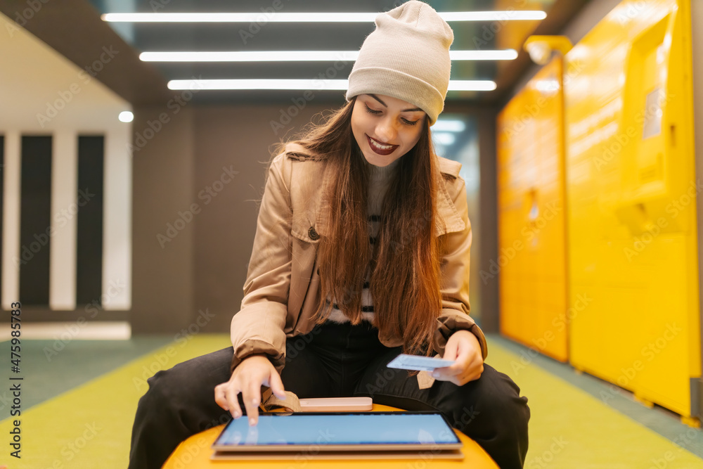 © Westend61 - Young woman doing online payment with credit card using touch screen laptop