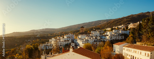 Sunset in the village of Valor in the Alpujarra of Granada with the bell tower of the church in the center of the photo photo