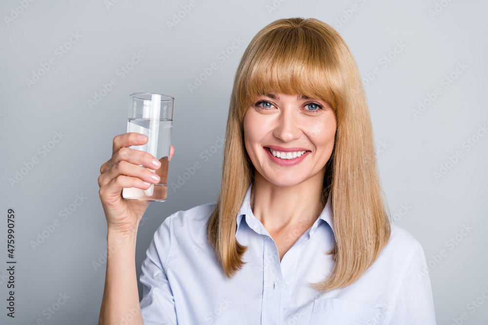 Portrait of positive executive boss lady hold water glass enjoy health care relax isolated grey color background Portrait of positive executive boss lady hold water glass enjoy health care relax isolated grey color background