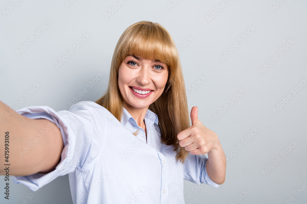 Self-portrait of attractive cheerful girl employer showing thumbup ad advert isolated over grey pastel color background Self-portrait of attractive cheerful girl employer showing thumbup ad advert isolated over grey pastel color background