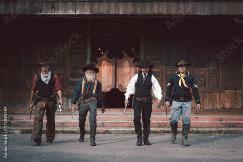 Fotografia Vintage style cowboys group wearing cowboy shirts and trousers everybody showing gun in hand ,like group of bank robber