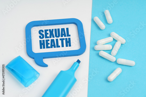 On the white and blue surface are a marker, tablets and a plate inside which the inscription - SEXUAL HEALTH